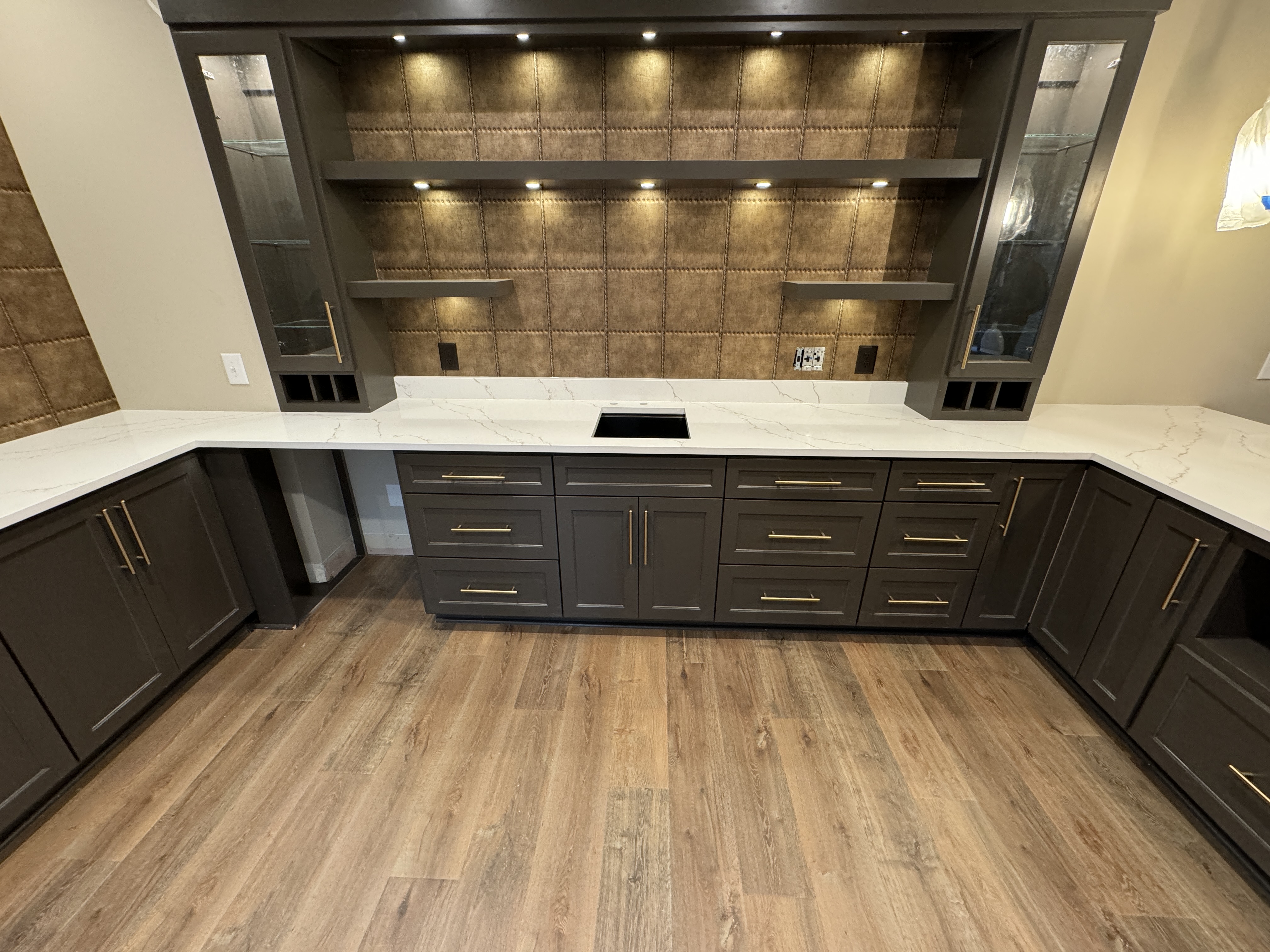 Modern bar area with white quartz countertops and dark cabinetry