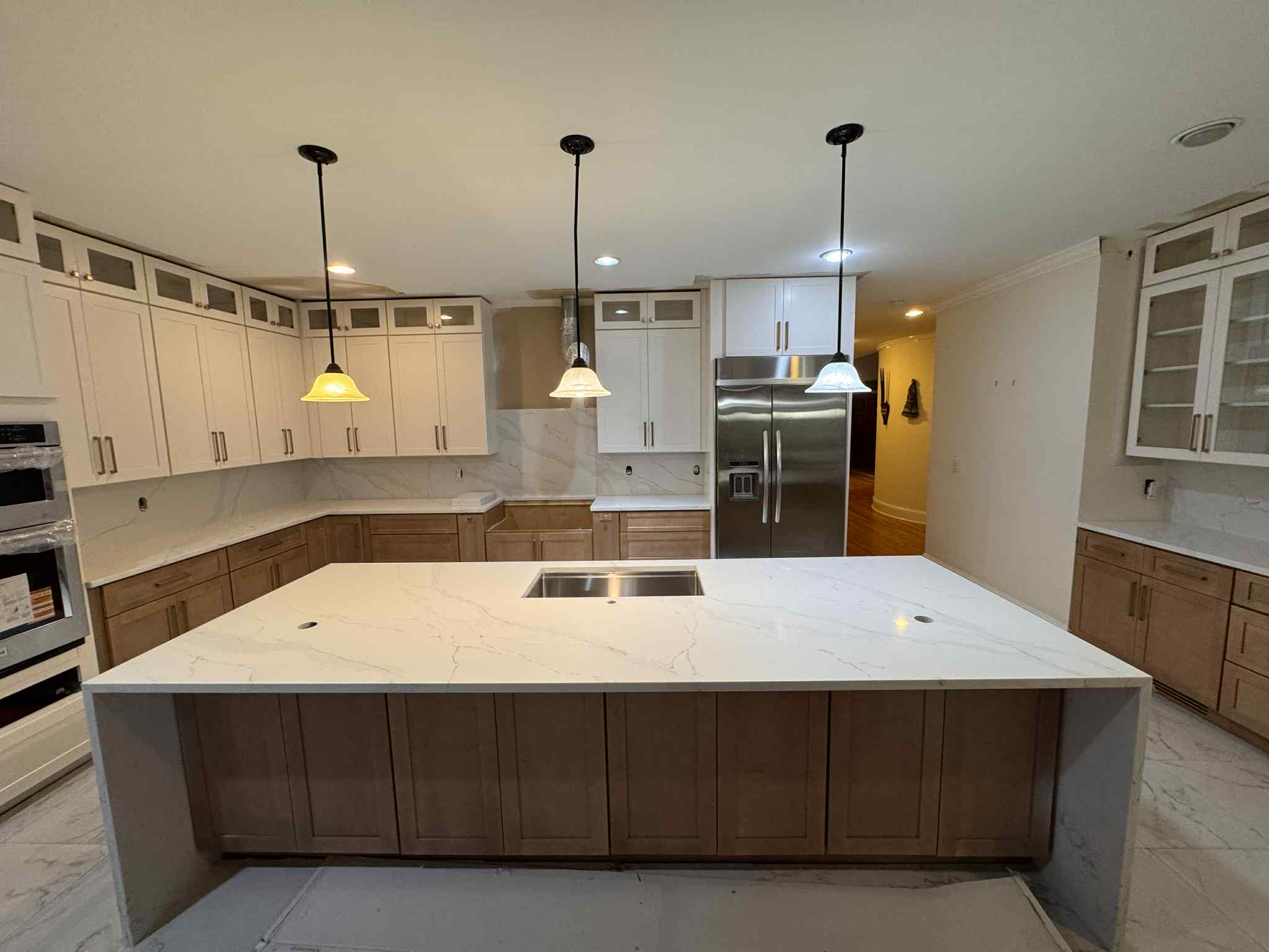 Modern kitchen with white quartz countertop island and two-tone cabinetry